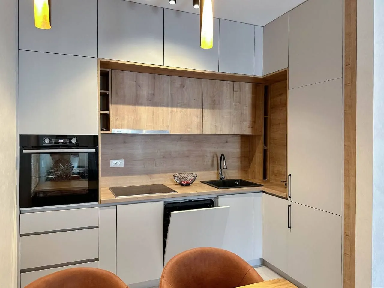 Modern kitchen with built-in appliances and wooden details.