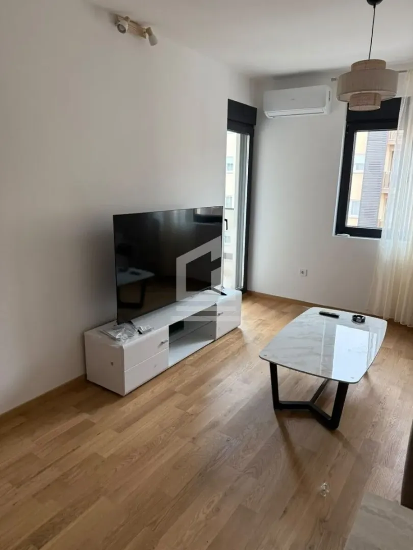 Dnevni boravak sa televizorom, komodom i stočićem.