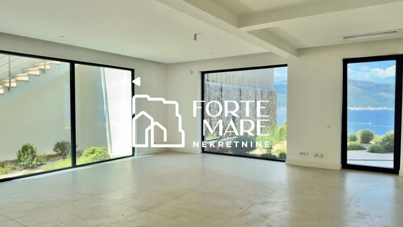 Empty living room with large glass surfaces and a sea view.