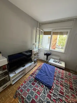 Small bedroom with a bed, TV, and window. - image 9