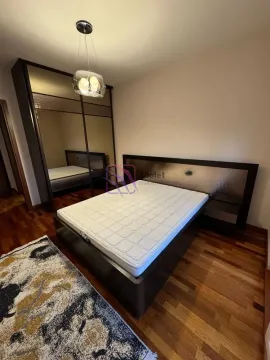 Furnished bedroom with a double bed, large wardrobe, and wooden flooring. - image 5