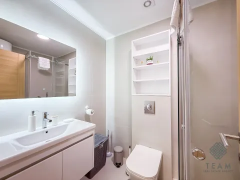 Modern bathroom with a washbasin, built-in toilet, and shower cabin. - image 7