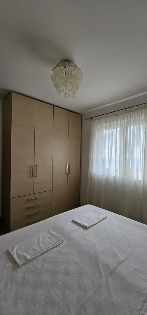 Uređena spavaća soba sa velikim garderoberom i bračnim krevetom.