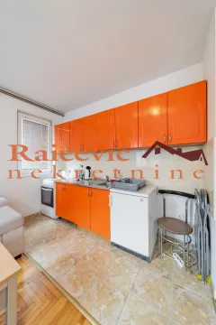 Kitchen with orange cabinets and basic appliances. - image 6