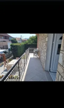 A long tiled terrace with a metal railing and a view of the yard. - image 15