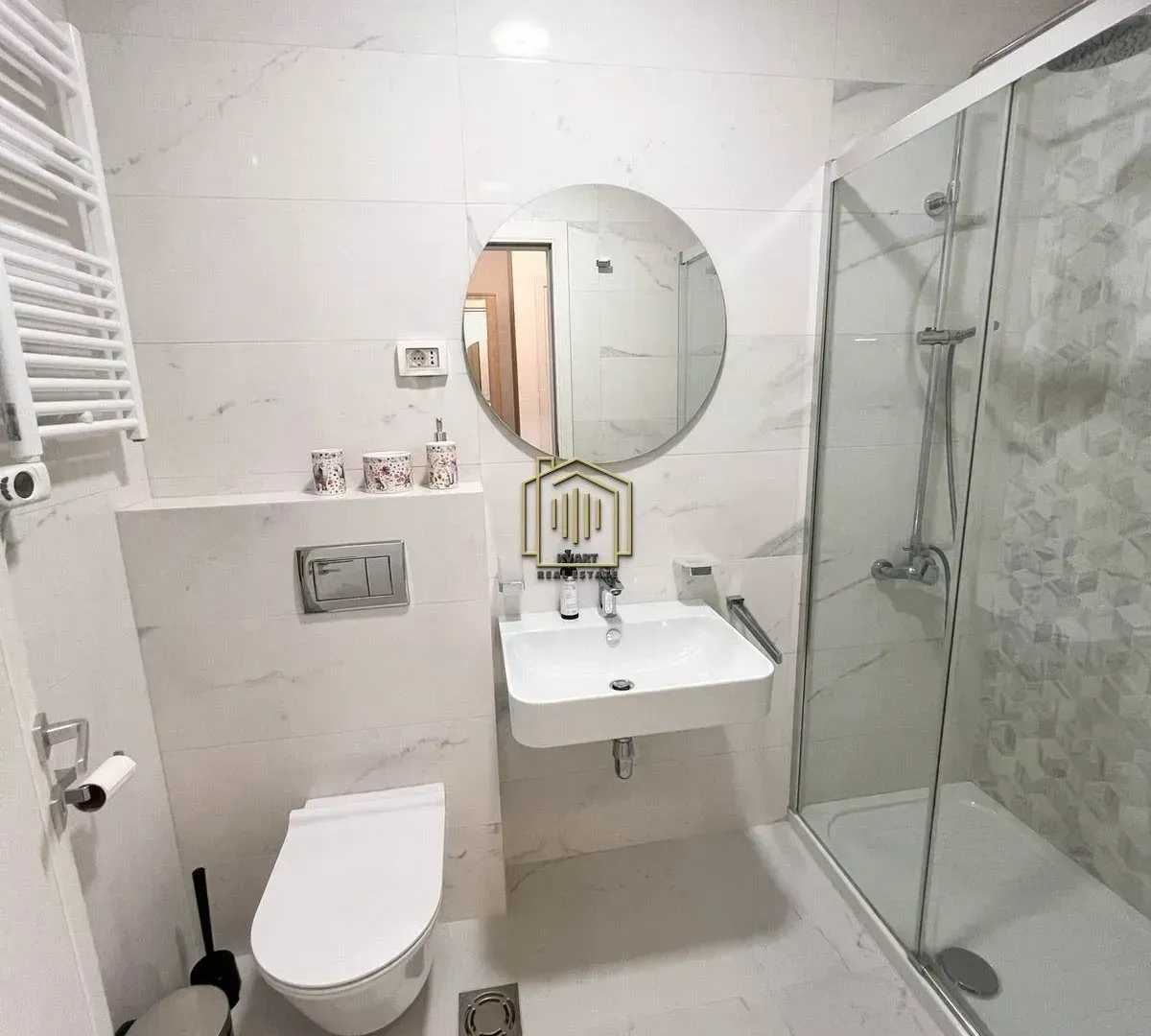 Savremeno opremljeno kupatilo sa tuš kabinom, umivaonikom i ugradnom wc šoljom.