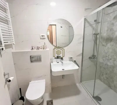 Savremeno opremljeno kupatilo sa tuš kabinom, umivaonikom i ugradnom wc šoljom. - image 6