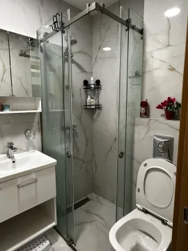 Moderne kupatilo sa tuš kabinom, umivaonikom i wc šoljom obloženo mermernim pločicama. - image 6