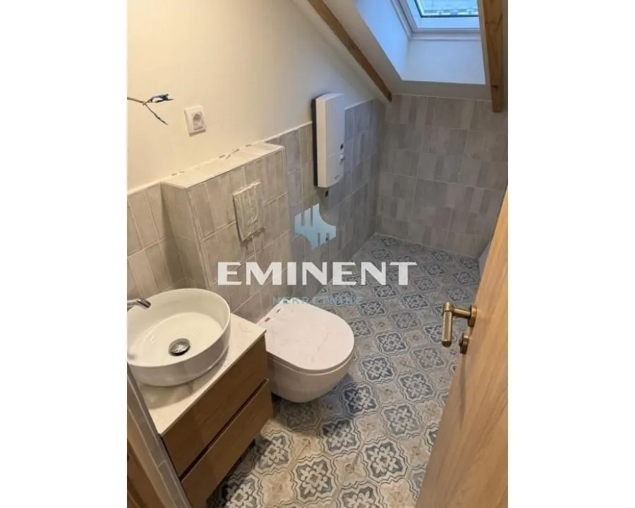 Smaller bathroom with a washbasin, toilet, and roof window.