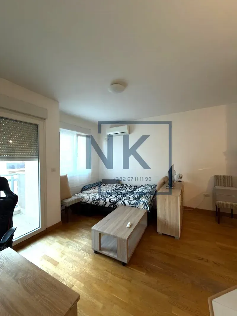 Furnished bedroom with a bed, desk, and balcony access.