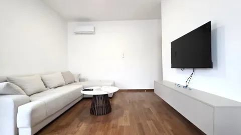 Dnevna soba sa ugaonom garniturom, stočićem, televizorom i klima uređajem. - image 2