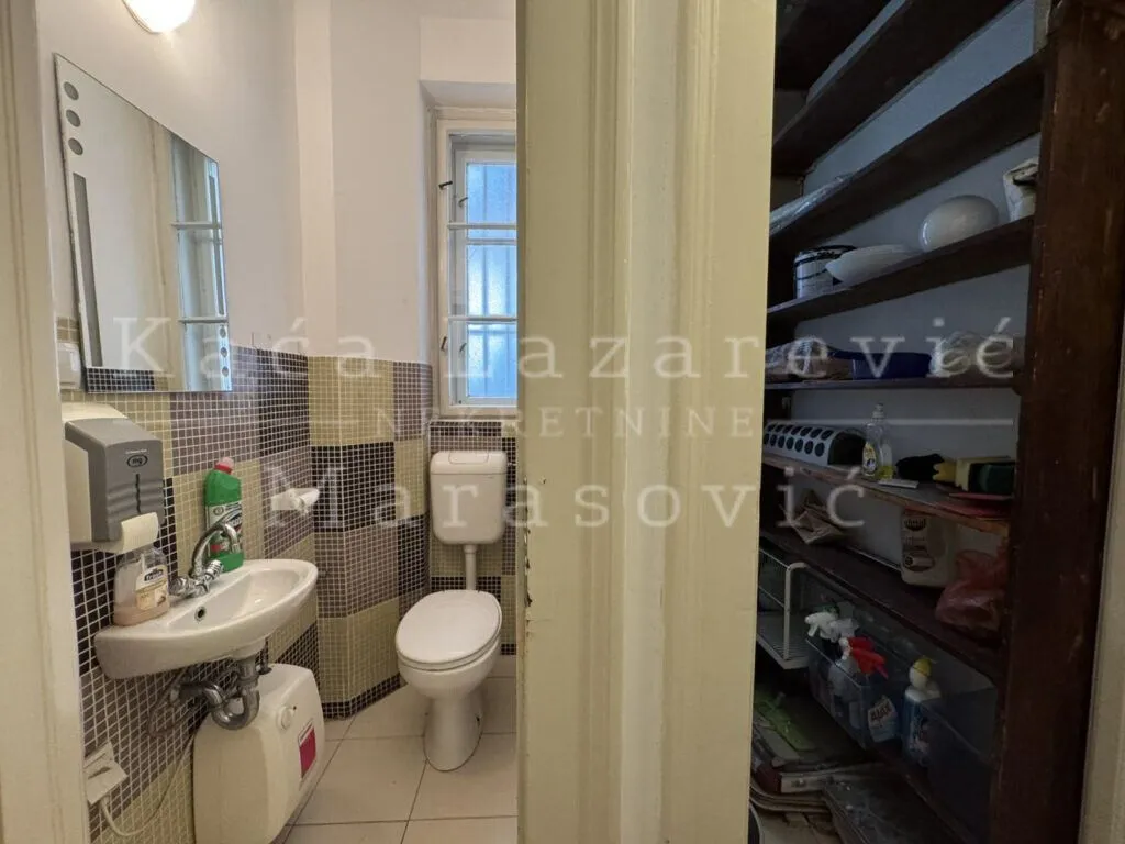 Manje kupatilo sa lavaboom, wc šoljom i mozaik pločicama.