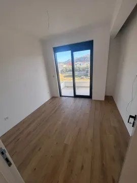 Prazna soba sa drvenim podom i izlazom na balkon. - image 11