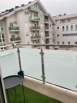 Manji balkon sa staklenom ogradom i pogledom na susjedne zgrade. - image 7