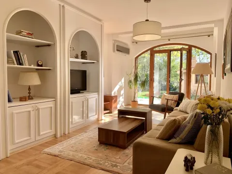 A bright living room with built-in shelves and a yard view. - image 5