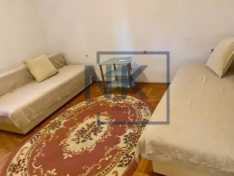 Dnevna soba sa dva ležaja, stočićem i tepihom. - image 4