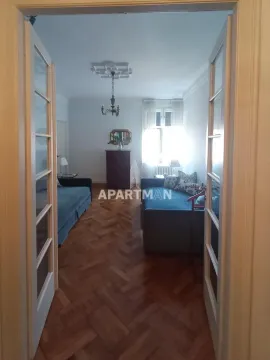 Pogled kroz vrata na dnevnu sobu sa garniturom i drvenim podom. - image 2