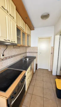 Manja kuhinja sa svetlim elementima, šporetom i radnom površinom. - image 7