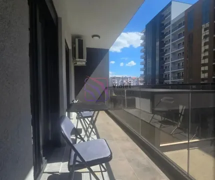 Covered balcony with seating furniture and a view of surrounding buildings. - image 12