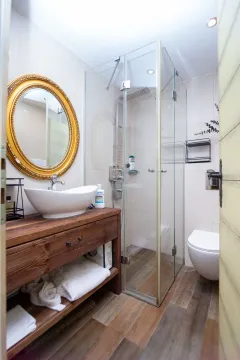 Modern bathroom with a wooden vanity, vessel sink, and glass shower enclosure. - image 6