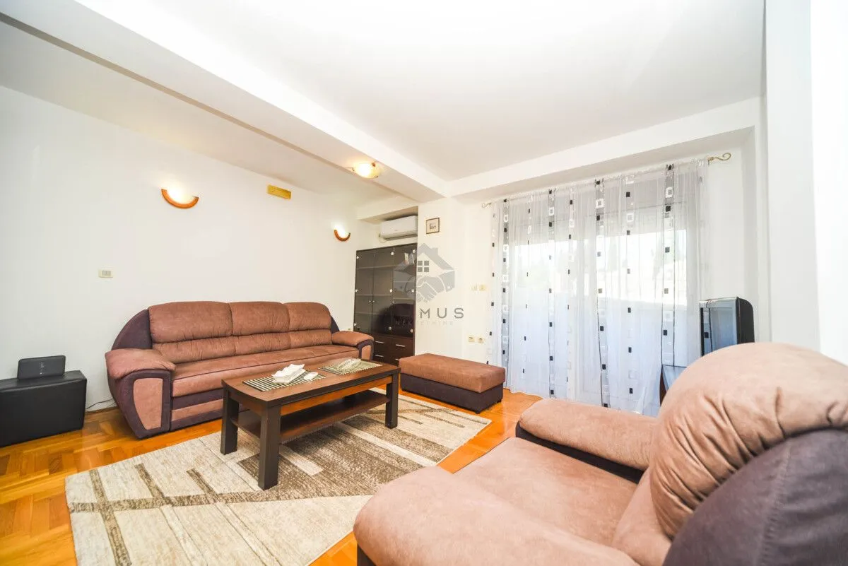 Living room with sofa set, coffee table and balcony access.