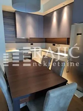 Modern kitchen with a dining area and built-in appliances. - image 6