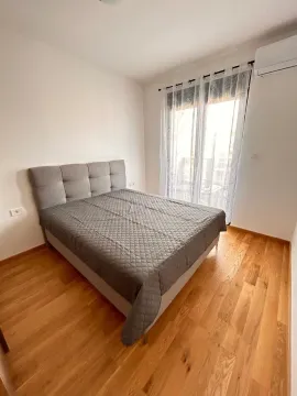 A bright bedroom featuring a double bed and wooden flooring. - image 7