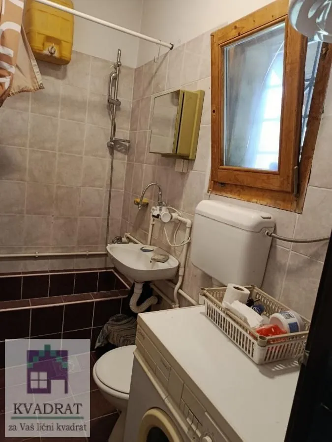 Manje kupatilo sa sanitarijama, tušem i prozorom.