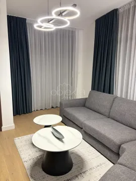 Dnevna soba sa udobnom sivom garniturom, stočićima i modernim osvjetljenjem. - image 4