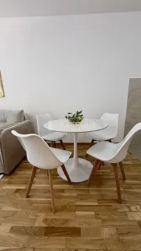 Dining table with four white chairs in the living room. - image 4