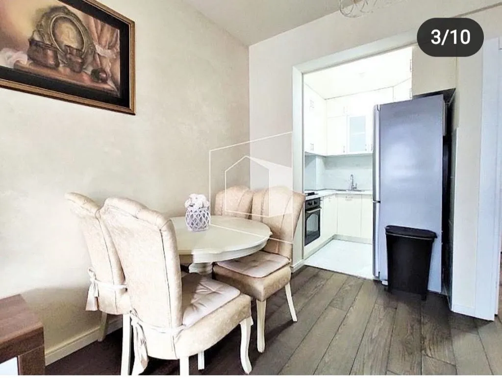 Dining area with a table and chairs and a view of the kitchen.
