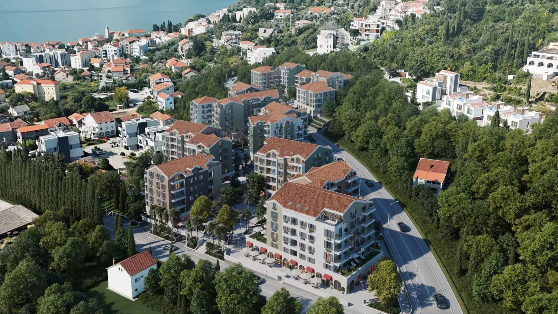 Prikaz modernog stambenog kompleksa blizu mora iz ptičije perspektive.