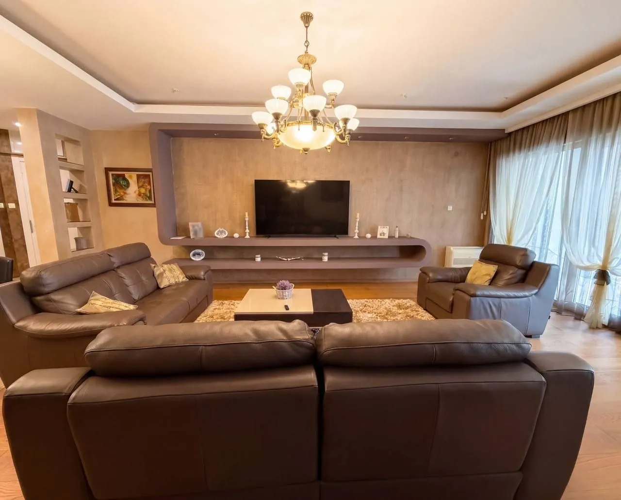 Spacious and bright living room with a seating set and TV unit.