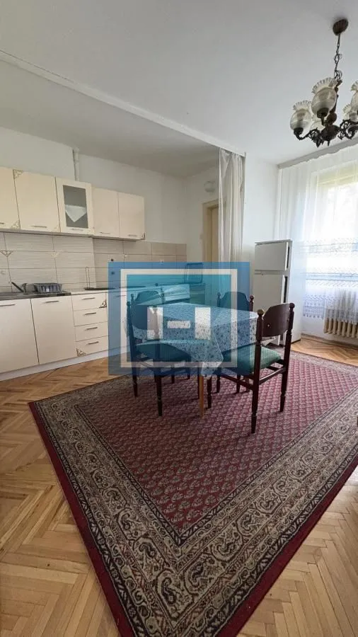 Kuhinja sa trpezarijom opremljena osnovnim elementima i stolom za ručavanje.