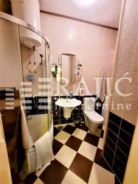 Small bathroom with a shower cabin, washbasin, and toilet. - image 10