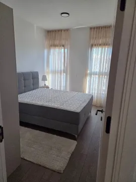 Modern bedroom with a double bed and bright windows. - image 4