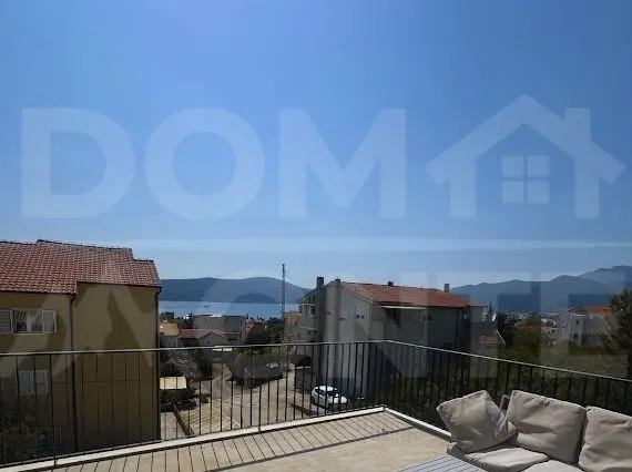 Terasa sa garniturom za sjedenje i pogledom na more i okolne zgrade.