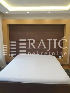 Bedroom with a double bed and a decorative headboard. - image 6