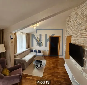 Living room with sofa, TV and decorative brick wall. - image 4
