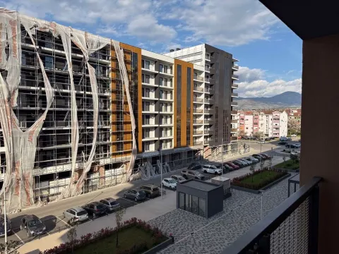 View from the terrace overlooking surrounding buildings, parking lot, and distant mountains. - image 3