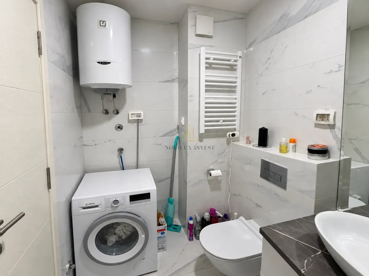 Moderne kupatilo opremljeno sanitarijama, veš mašinom i bojlerom.