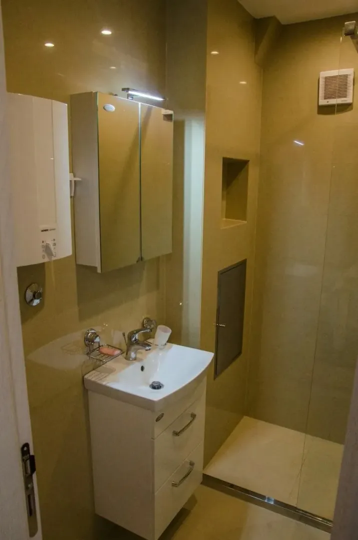 A bathroom with white fixtures and a shower.