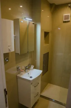 A bathroom with white fixtures and a shower. - image 8