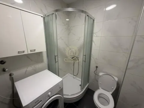Kupatilo sa tuš kabinom, toaletom, mašinom za veš i zidnim elementom. - image 6