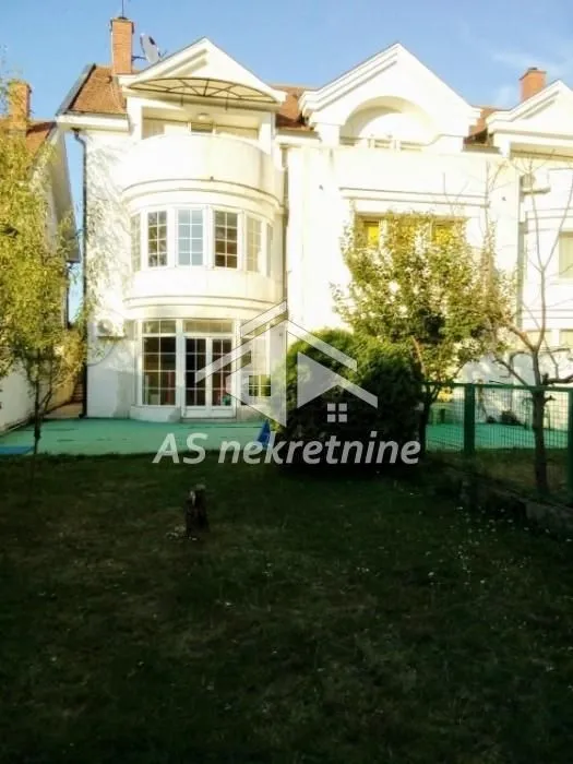 View of the back of the house with a yard and terrace.
