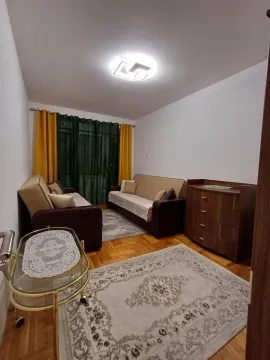 Svijetla dnevna soba sa dva kauča, komodom i tepihom. - image 5