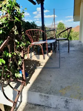 Natkrivena terasa sa metalnim stolom i stolicama i pogledom na okolinu. - image 8