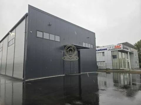 Exterior view of a modern industrial warehouse with an asphalted courtyard. - image 4