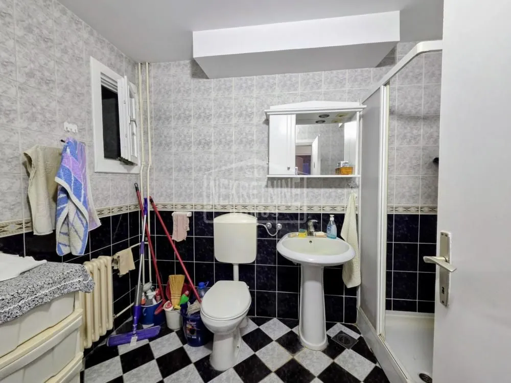 Manje kupatilo sa tuš kabinom, lavaboom i WC šoljom.