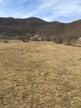 Pogled na prostranu livadu i brda u pozadini. - image 4